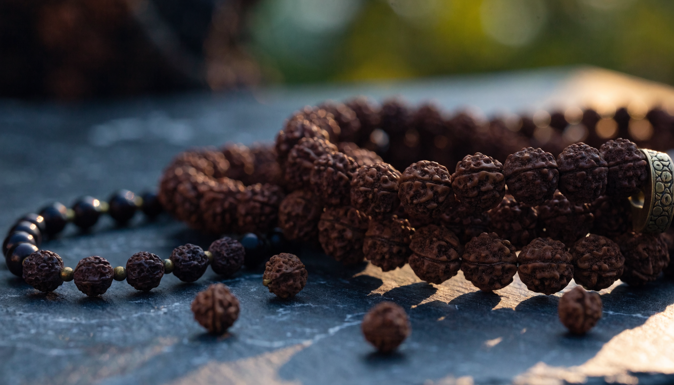 Natural Nepali Rudraksha bead malas on a dark surface, individually certified by GemsMantra